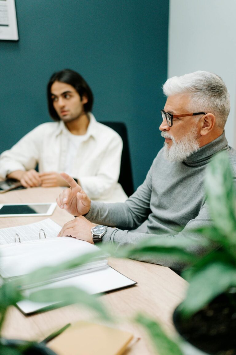 Senior and young professionals in a focused business meeting discussing strategy.